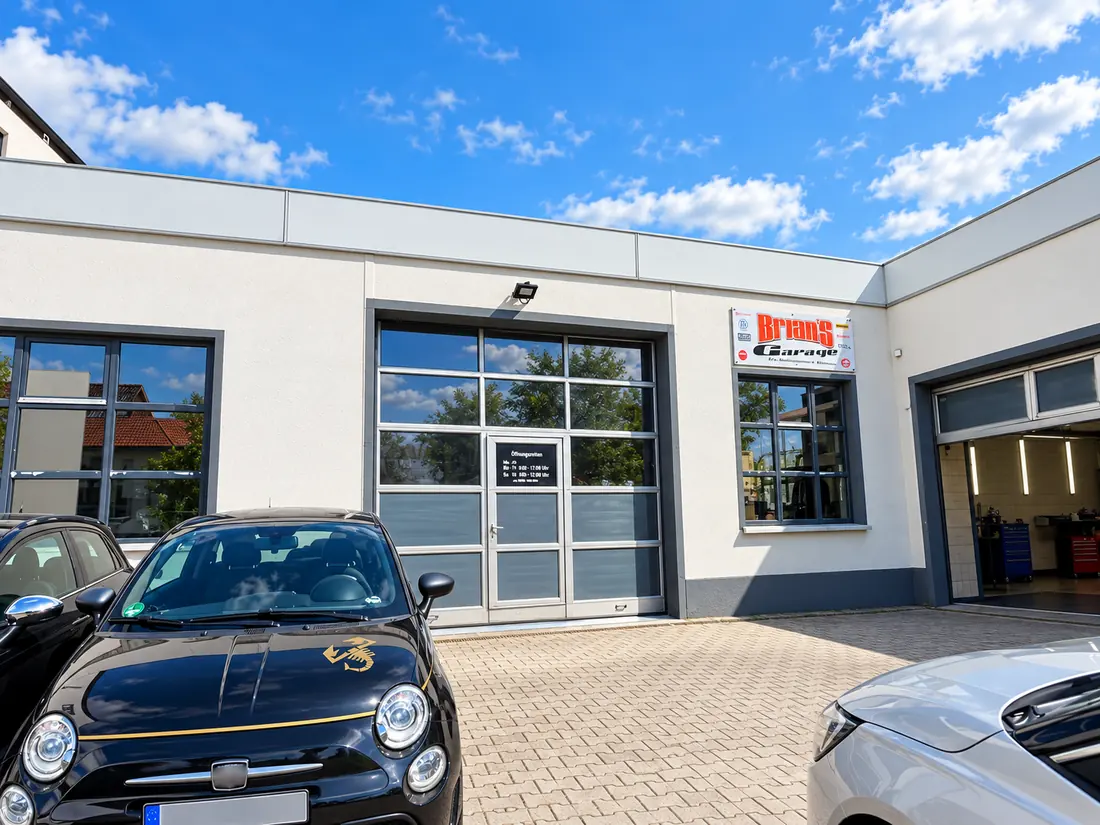 Fahrzeuge auf dem Hof vor der Werkstatt