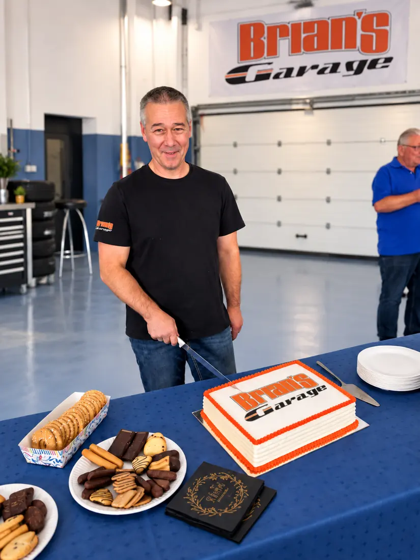 Mitarbeiter schneidet eine Torte mit dem Logo von Brian's Garage an